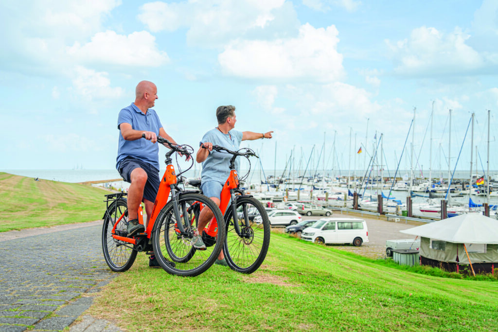 Paar hält Nordseeräder und schaut über den Hafen