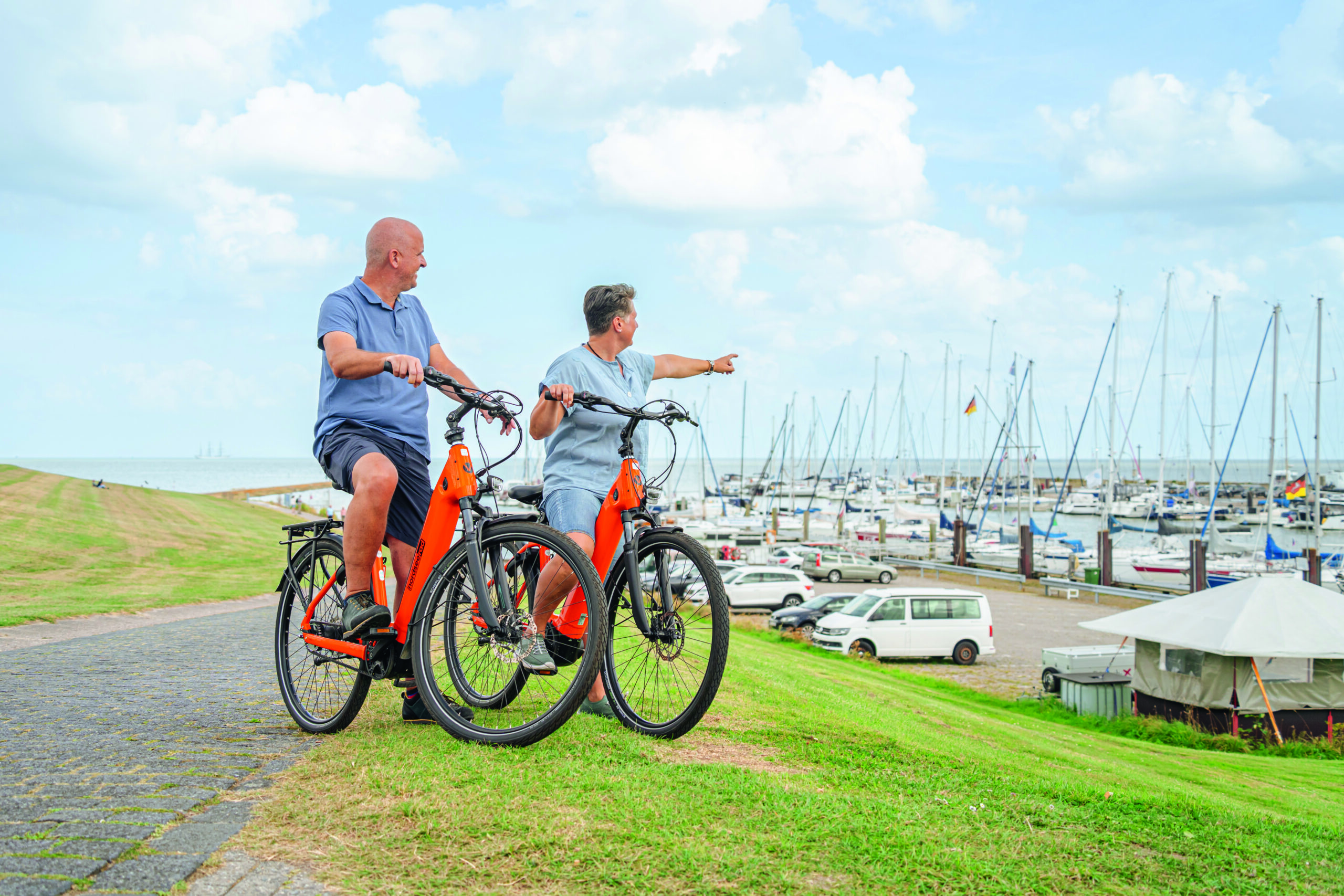 Pärchen auf Rad sitzend vor Hafen