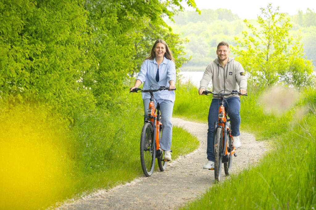 Radtour mit gemieteten NordseeRad E-Bikes in Carolinensiel
Pärchen fährt mit zwei Rädern durch die Wälder