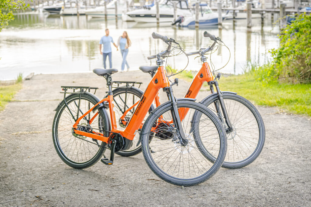 Pärchen vor Wasser im Vordergrund 2 E-Bikes