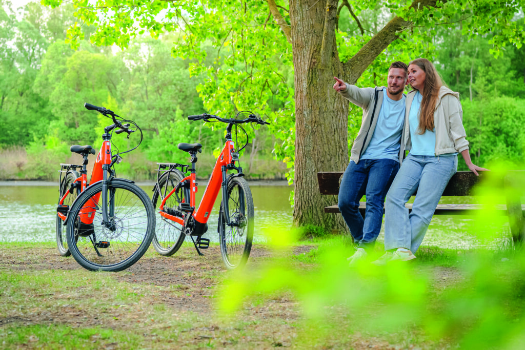 Paar steht vor Bank mit Nordseeräder daneben